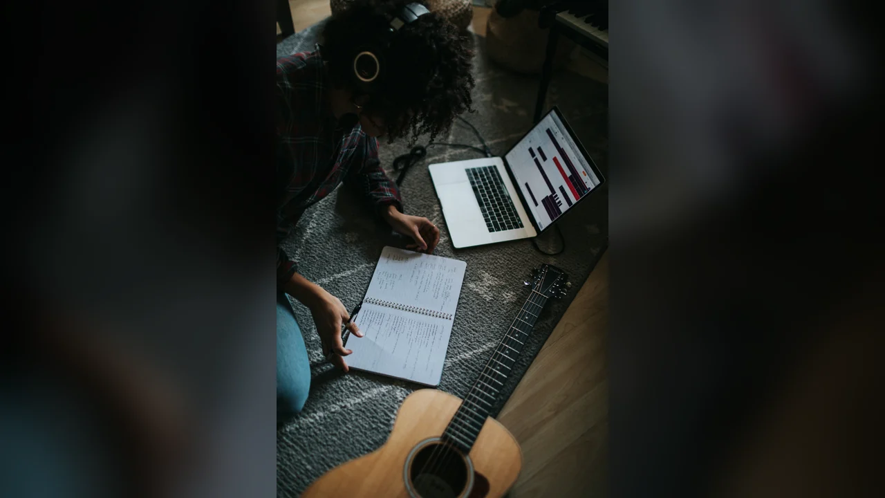 SongCoverGen Custom mode: songwriter writing new lyrics in a notebook beside a guitar